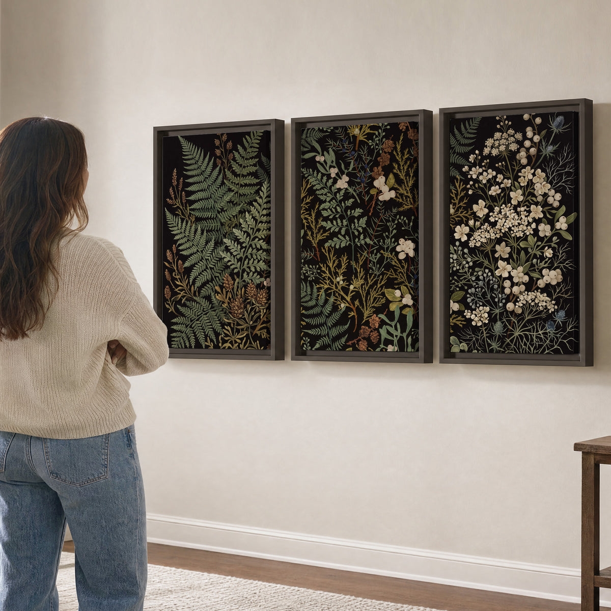 Layered green ferns and delicate cream flowers on a black background 3 piece framed canvas wall art three panel arrangement on a wall