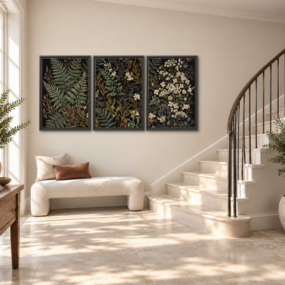 Layered green ferns and delicate cream flowers on a black background 3 piece framed canvas wall art styled in an interior