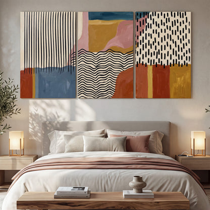 Terracotta, pink, mustard and blue shapes with black line patterns 3 piece canvas wall art displayed in a bedroom