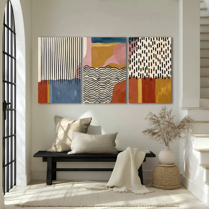 Terracotta, pink, mustard and blue shapes with black line patterns 3 piece canvas wall art displayed in a entryway