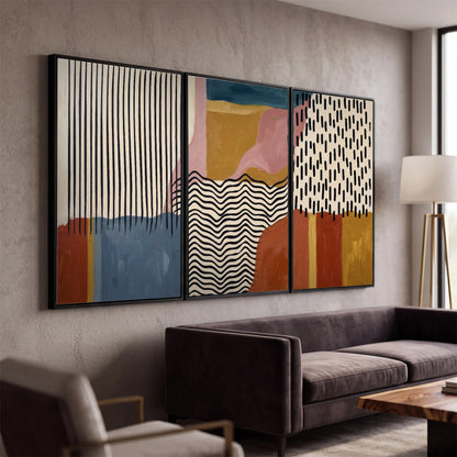 Terracotta, pink, mustard and blue shapes with black line patterns 3 piece framed canvas wall art displayed in a modern living room