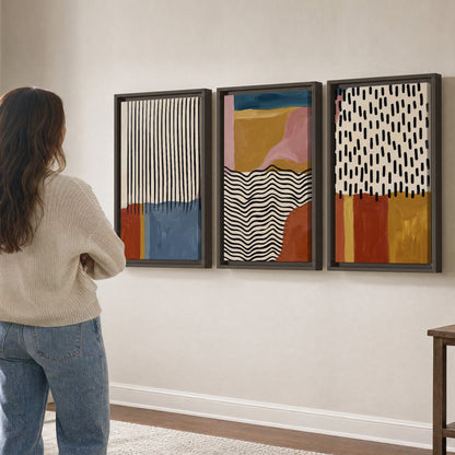 Terracotta, pink, mustard and blue shapes with black line patterns 3 piece framed canvas wall art three panel arrangement on a wall