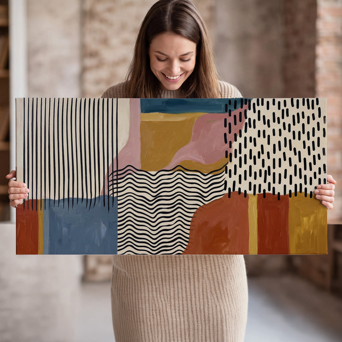 Terracotta, pink, mustard and blue shapes with black line patterns single canvas wall art held in hands