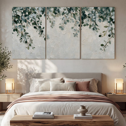 Soft green eucalyptus branches on a cream background 3 piece canvas wall art displayed in a bedroom