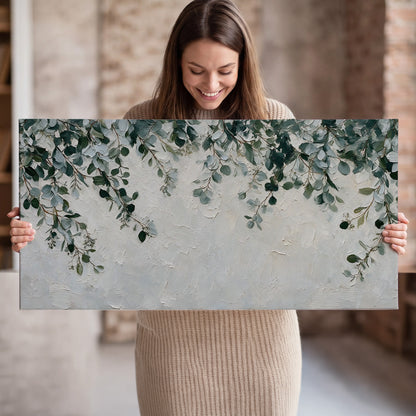 Soft green eucalyptus branches on a cream background single canvas wall art held in hands