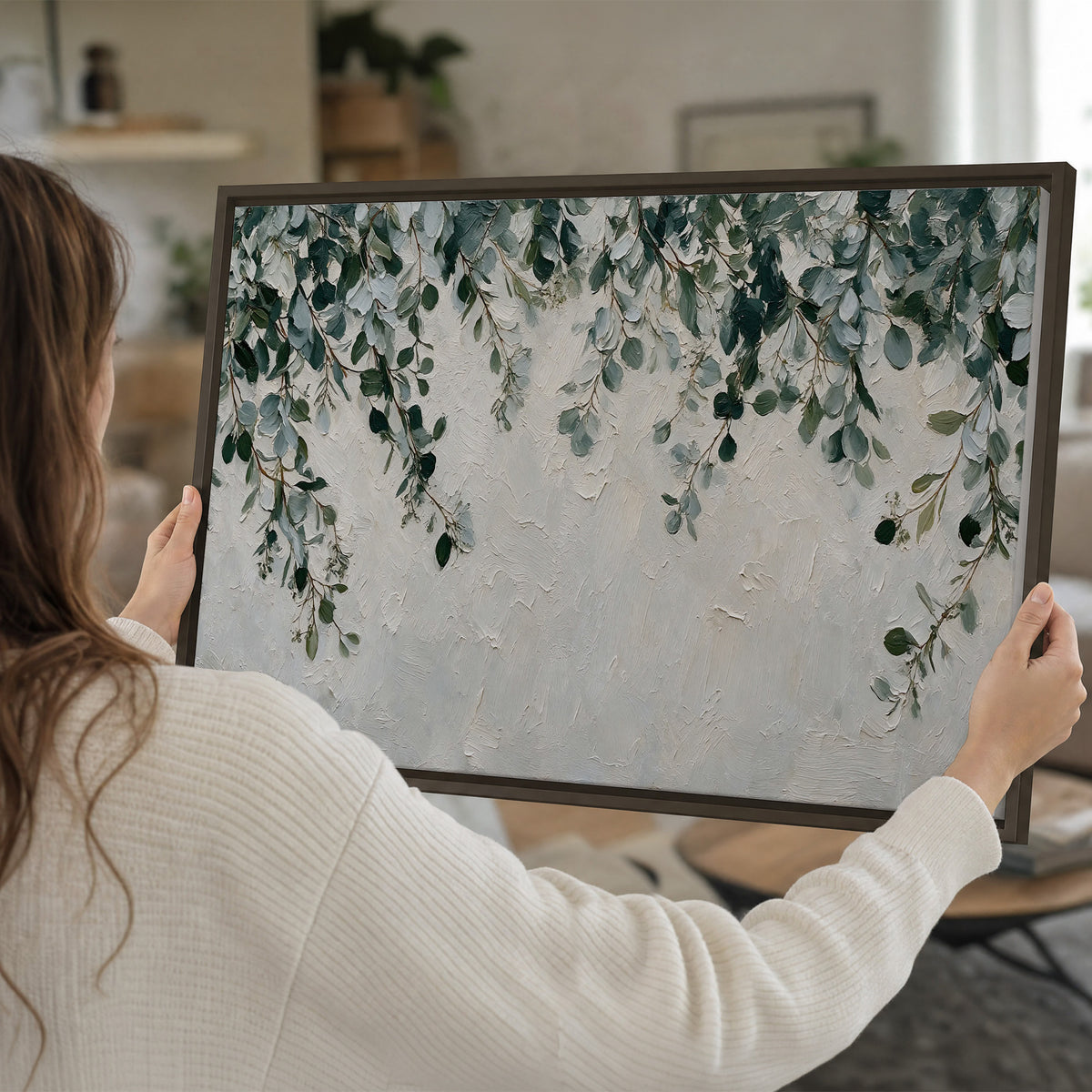 Soft green eucalyptus branches on a cream background single framed canvas wall art held in hands