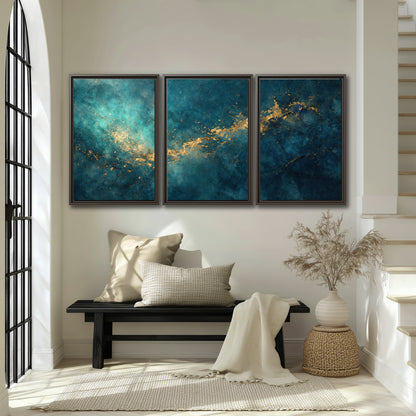 Deep teal clouds with sweeping gold-colored accents 3 piece framed canvas wall art displayed in a entryway