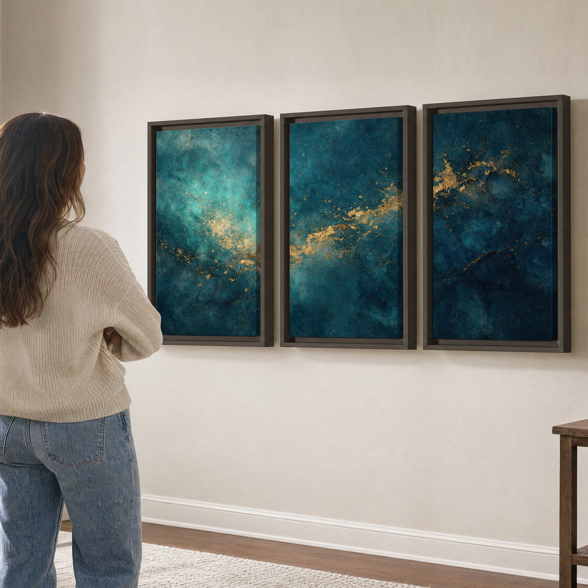 Deep teal clouds with sweeping gold-colored accents 3 piece framed canvas wall art three panel arrangement on a wall