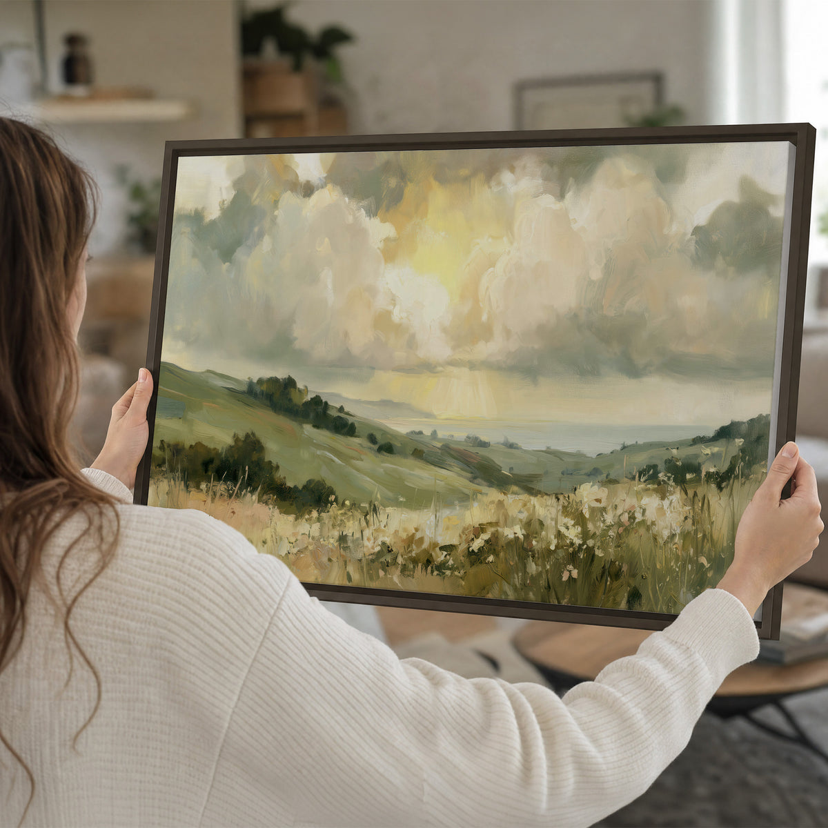 Rolling green hills beneath a luminous cloudy sky single framed canvas wall art held in hands