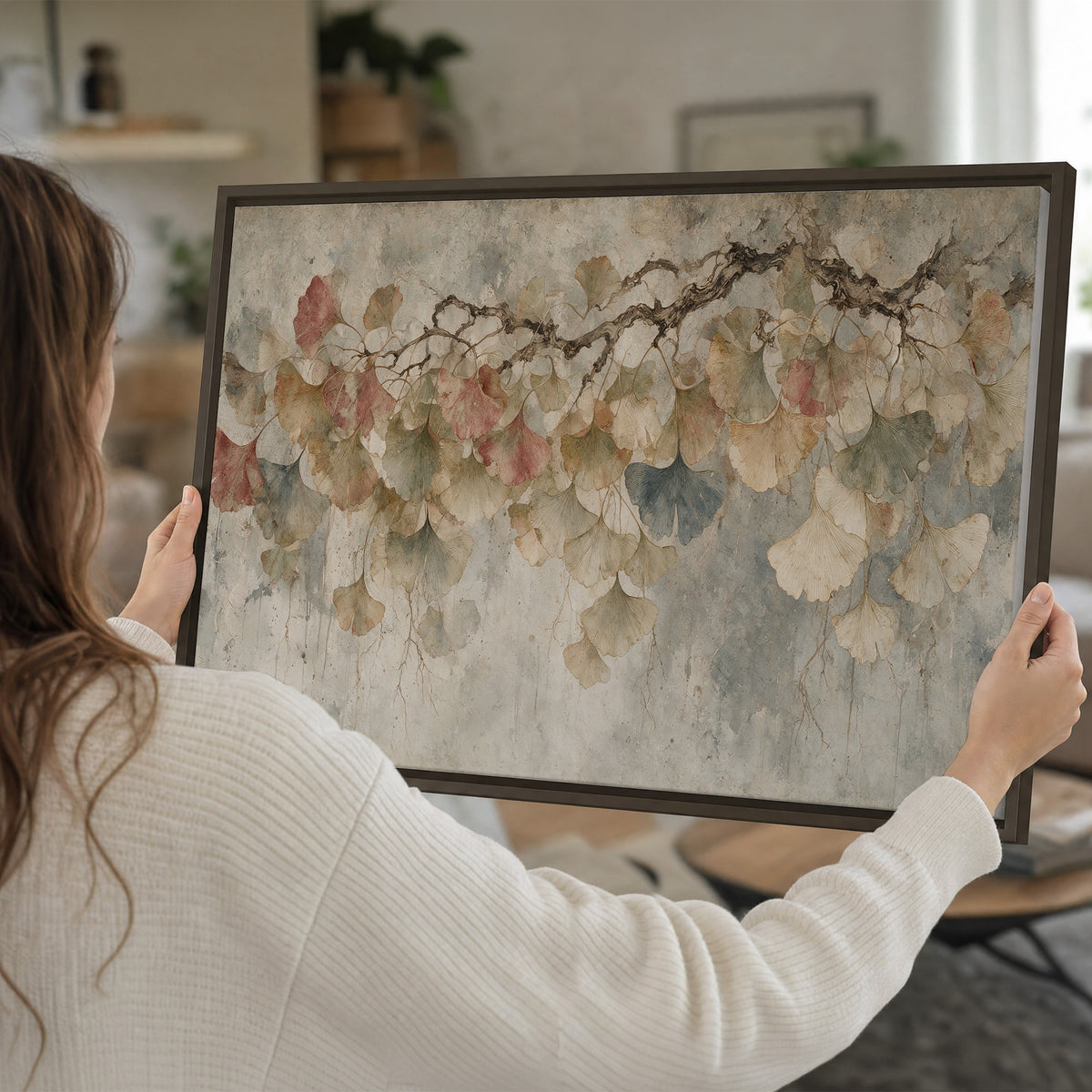 Cream and blush ginkgo leaves on delicate branches single framed canvas wall art held in hands