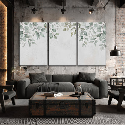 Pale sage eucalyptus leaves against a light background 3 piece canvas wall art displayed in a industrial room