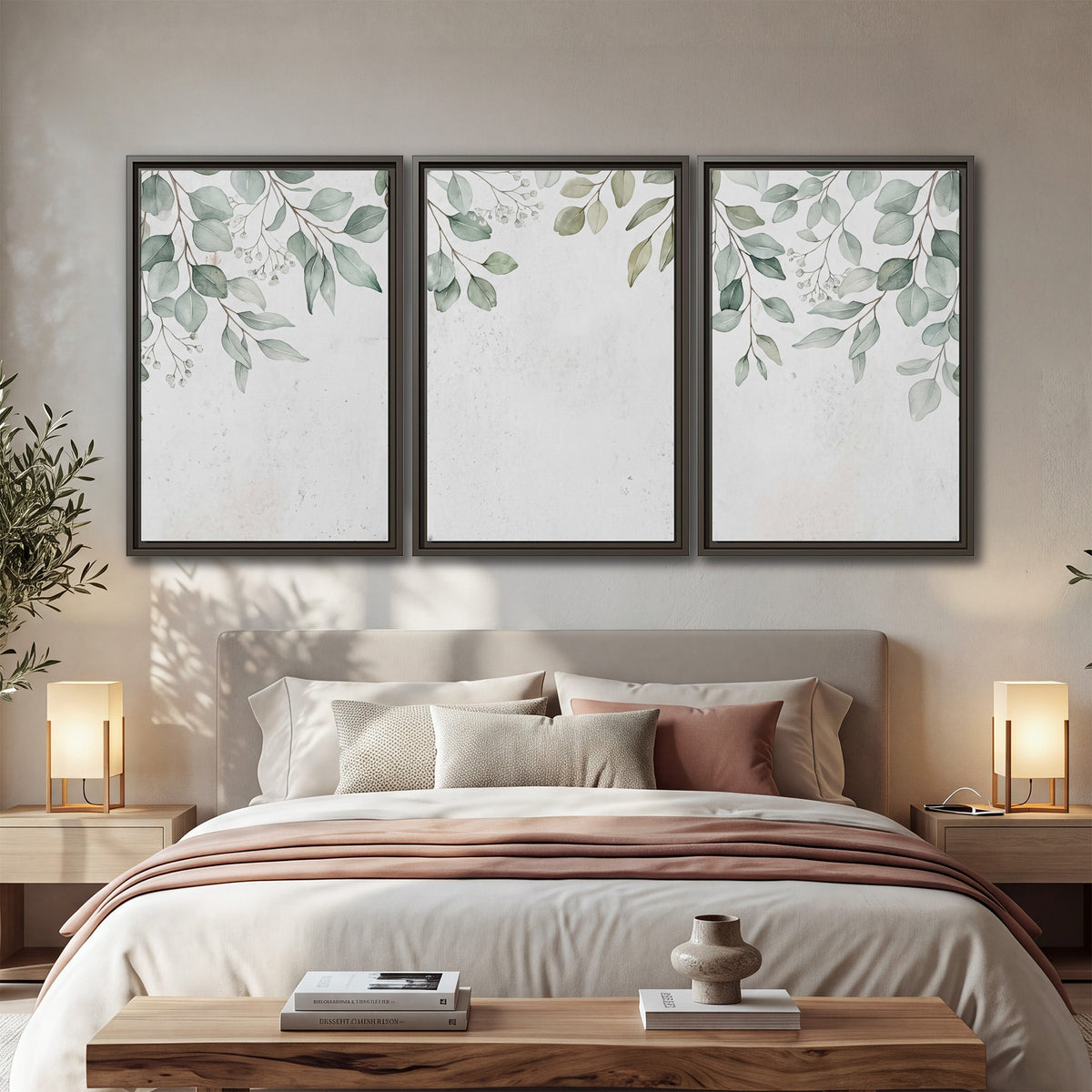 Pale sage eucalyptus leaves against a light background 3 piece framed canvas wall art displayed in a bedroom