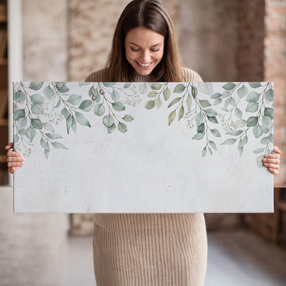 Pale sage eucalyptus leaves against a light background single canvas wall art held in hands