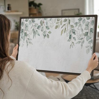 Pale sage eucalyptus leaves against a light background single framed canvas wall art held in hands