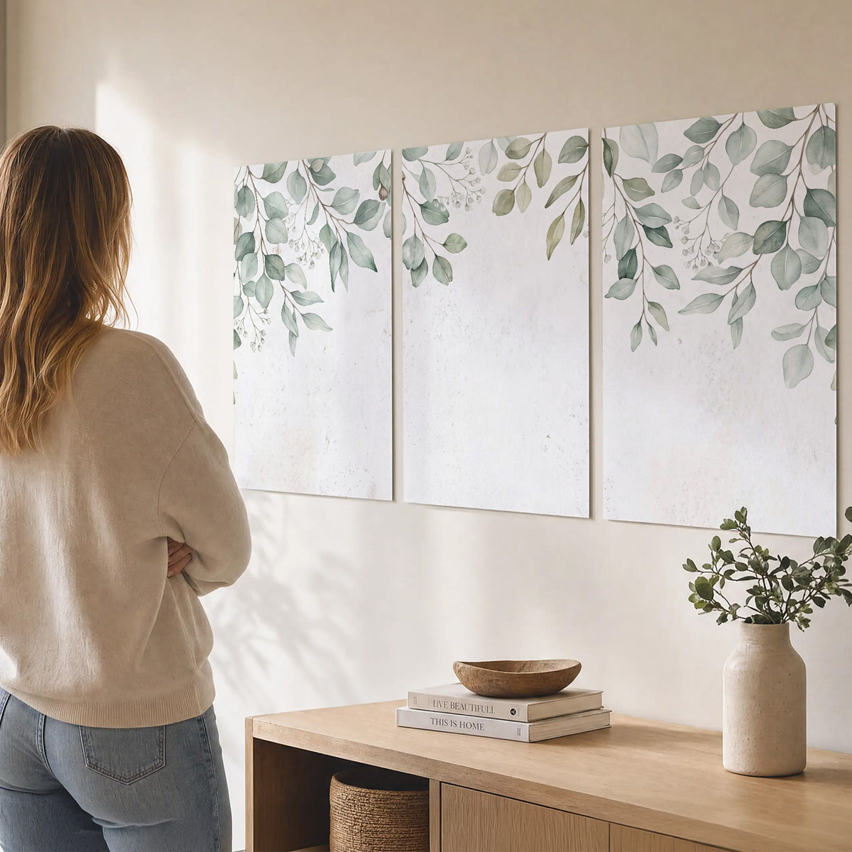 Pale sage eucalyptus leaves against a light background set of 3 poster prints three panel arrangement on a wall
