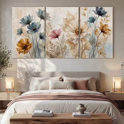 Airy blue, ochre and blush flowers on a warm cream background 3 piece canvas wall art displayed in a bedroom
