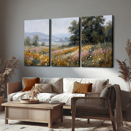 A flower-filled meadow overlooking soft blue mountain ridges 3 piece canvas wall art displayed in a rustic living room