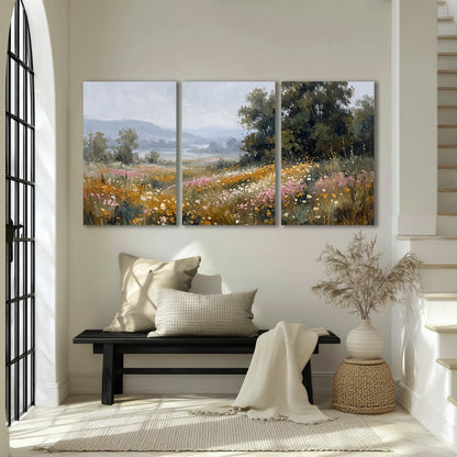 A flower-filled meadow overlooking soft blue mountain ridges 3 piece canvas wall art displayed in a entryway