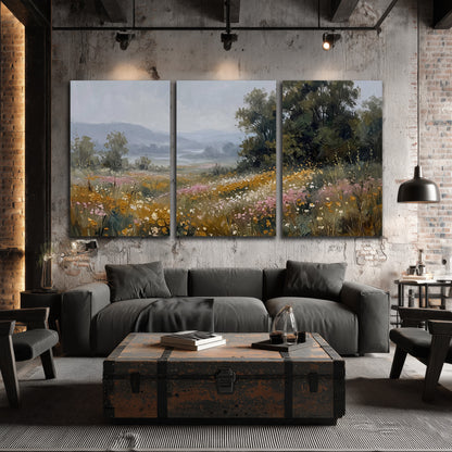 A flower-filled meadow overlooking soft blue mountain ridges 3 piece canvas wall art displayed in a industrial room