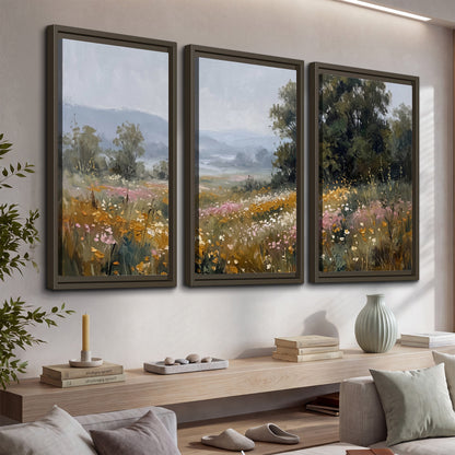 A flower-filled meadow overlooking soft blue mountain ridges 3 piece framed canvas wall art displayed in a console