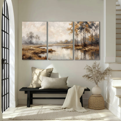 Warm autumn trees beside a quiet reflective river 3 piece canvas wall art displayed in a entryway