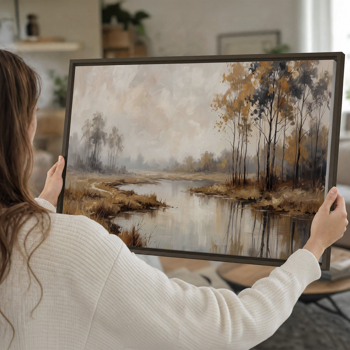 Warm autumn trees beside a quiet reflective river single framed canvas wall art held in hands