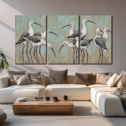 Long-legged white and gray wading birds against a muted aqua background 3 piece canvas wall art displayed in a living room