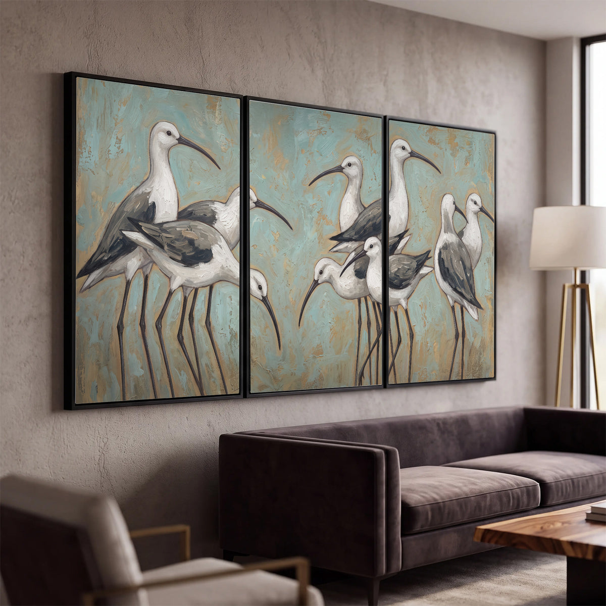 Long-legged white and gray wading birds against a muted aqua background 3 piece framed canvas wall art displayed in a modern living room