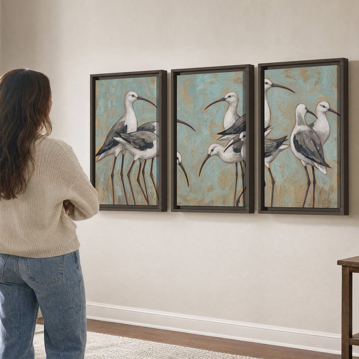 Long-legged white and gray wading birds against a muted aqua background 3 piece framed canvas wall art three panel arrangement on a wall