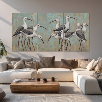 Long-legged white and gray wading birds against a muted aqua background set of 3 poster prints displayed in a living room
