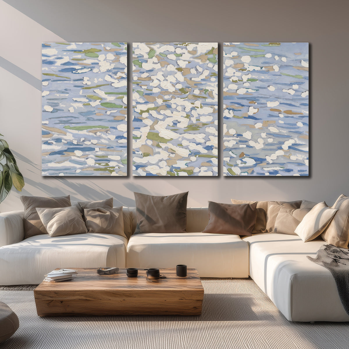 Loose pale blue, white and soft green marks suggesting shimmering water 3 piece canvas wall art displayed in a living room