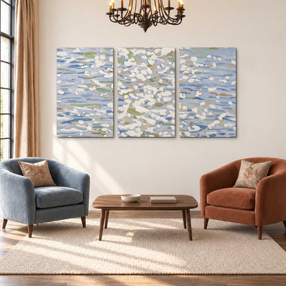 Loose pale blue, white and soft green marks suggesting shimmering water 3 piece canvas wall art styled in an interior