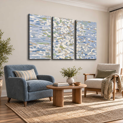Loose pale blue, white and soft green marks suggesting shimmering water 3 piece canvas wall art styled in an interior