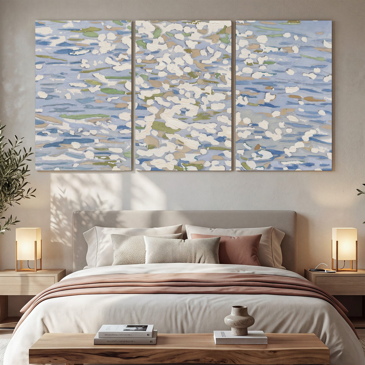 Loose pale blue, white and soft green marks suggesting shimmering water 3 piece canvas wall art displayed in a bedroom