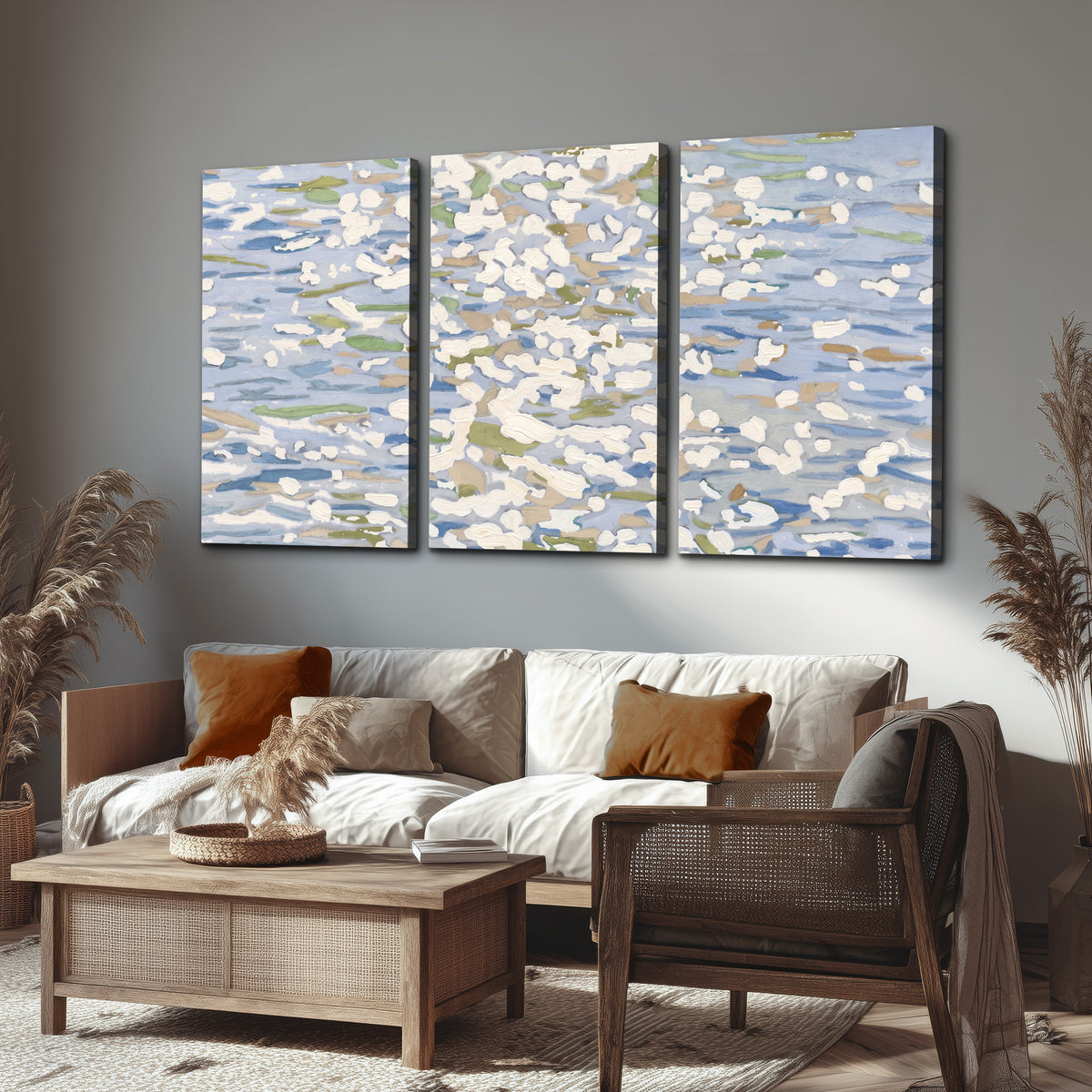 Loose pale blue, white and soft green marks suggesting shimmering water 3 piece canvas wall art displayed in a rustic living room