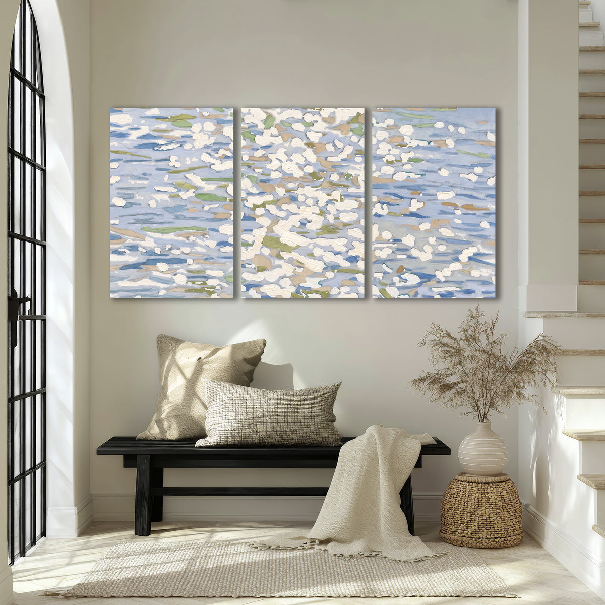 Loose pale blue, white and soft green marks suggesting shimmering water 3 piece canvas wall art displayed in a entryway