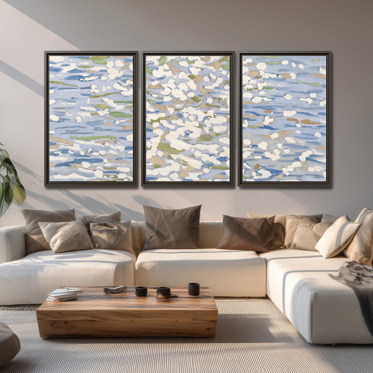 Loose pale blue, white and soft green marks suggesting shimmering water 3 piece framed canvas wall art displayed in a living room