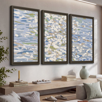 Loose pale blue, white and soft green marks suggesting shimmering water 3 piece framed canvas wall art displayed in a console