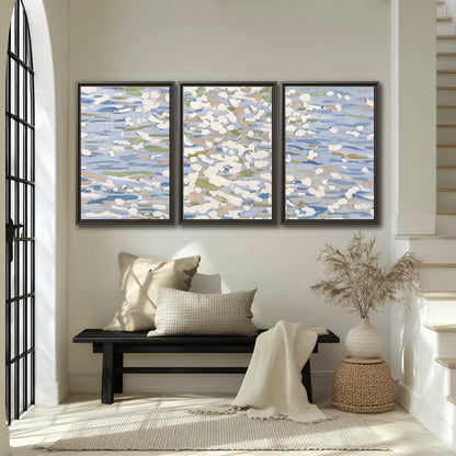 Loose pale blue, white and soft green marks suggesting shimmering water 3 piece framed canvas wall art displayed in a entryway