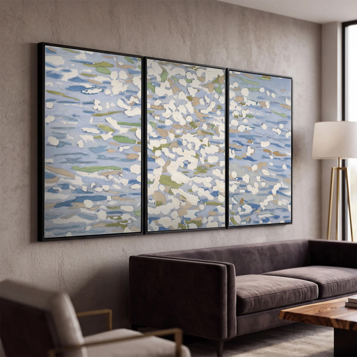 Loose pale blue, white and soft green marks suggesting shimmering water 3 piece framed canvas wall art displayed in a modern living room