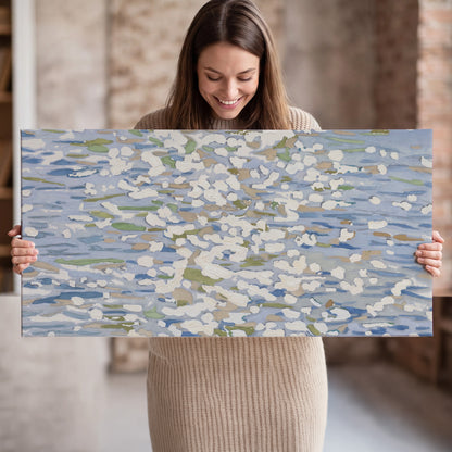 Loose pale blue, white and soft green marks suggesting shimmering water single canvas wall art held in hands