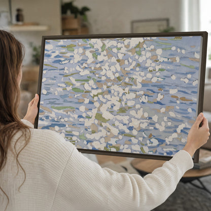 Loose pale blue, white and soft green marks suggesting shimmering water single framed canvas wall art held in hands