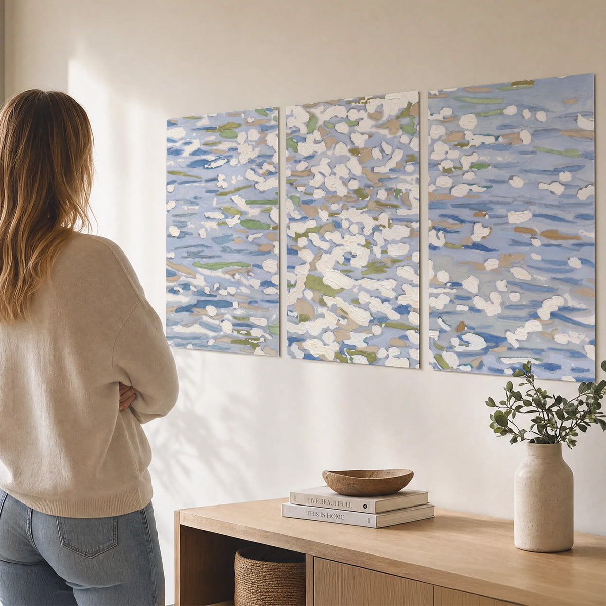 Loose pale blue, white and soft green marks suggesting shimmering water set of 3 poster prints three panel arrangement on a wall