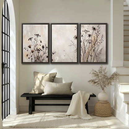 Fine dark wildflower stems and seed heads against soft beige 3 piece framed canvas wall art displayed in a entryway