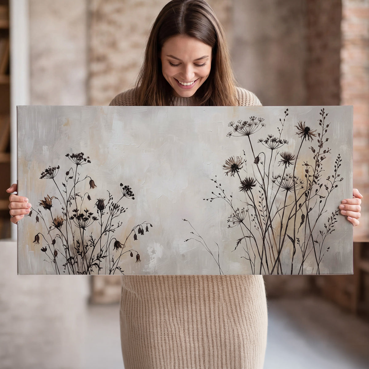 Fine dark wildflower stems and seed heads against soft beige single canvas wall art held in hands