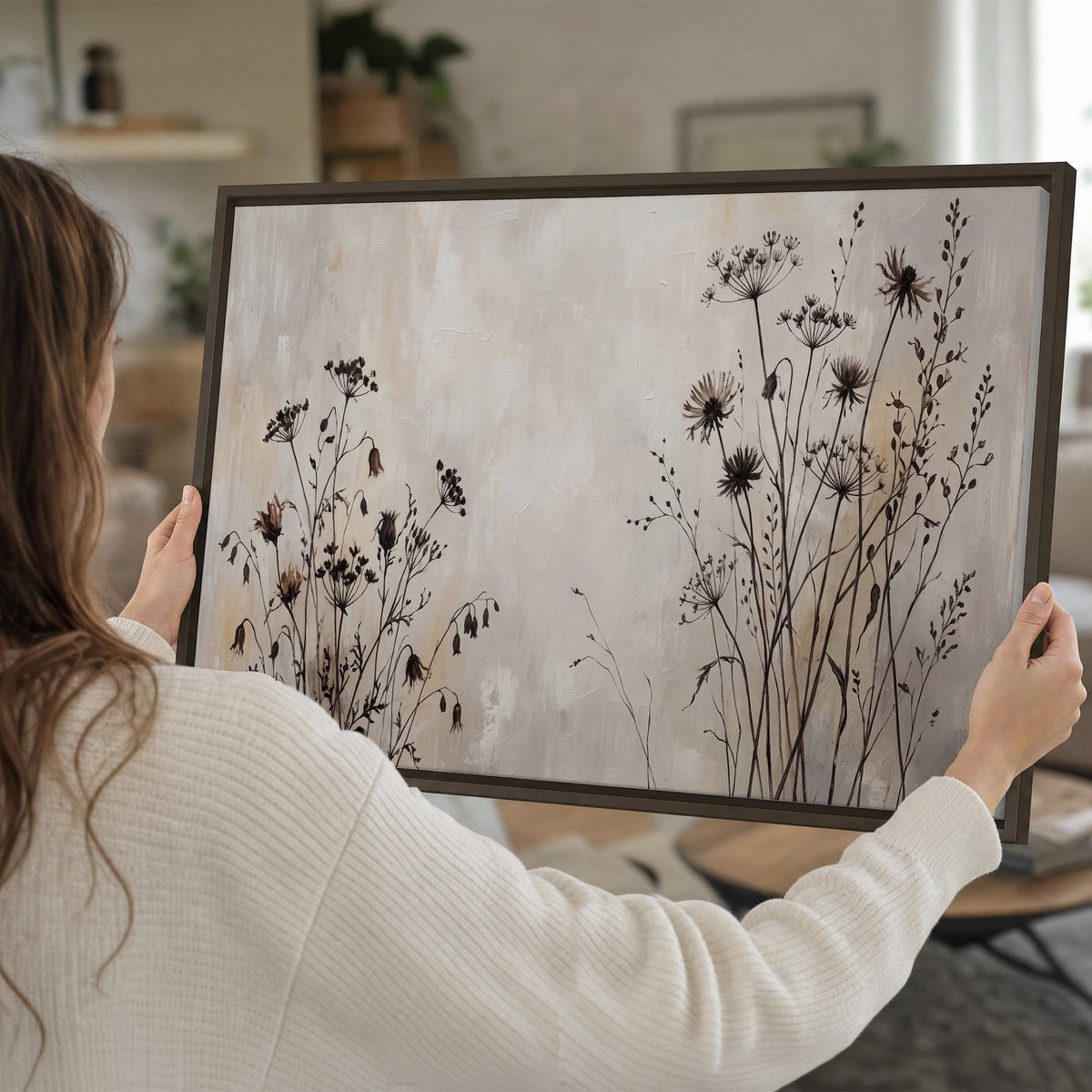 Fine dark wildflower stems and seed heads against soft beige single framed canvas wall art held in hands