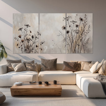 Fine dark wildflower stems and seed heads against soft beige set of 3 poster prints displayed in a living room