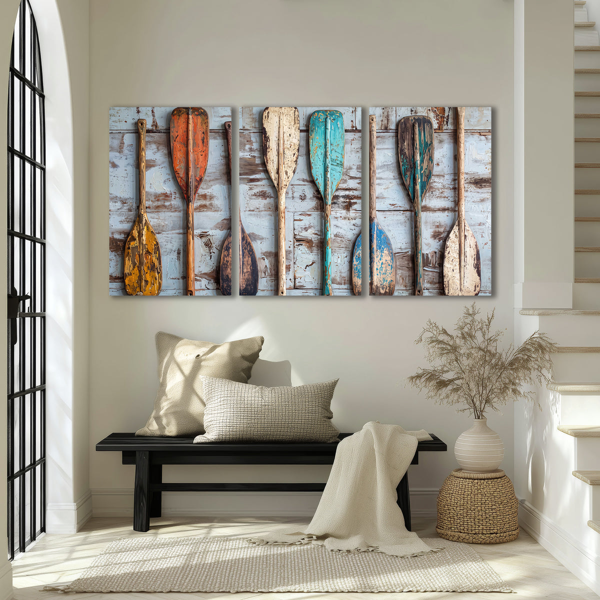 A row of colorful weathered wooden oars against pale blue boards 3 piece canvas wall art displayed in a entryway