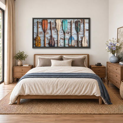 A row of colorful weathered wooden oars against pale blue boards single framed canvas wall art styled in an interior