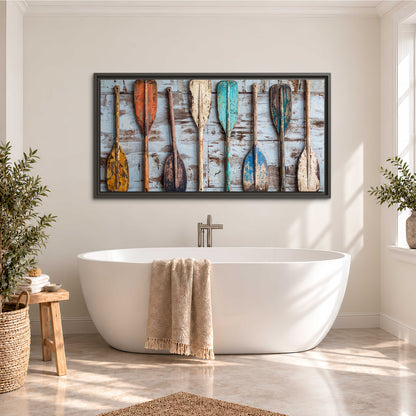 A row of colorful weathered wooden oars against pale blue boards single framed canvas wall art styled in an interior